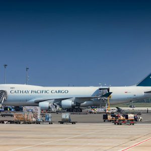 Cargo aircraft being loaded with freight containers at airport - air freight vs sea freight comparison