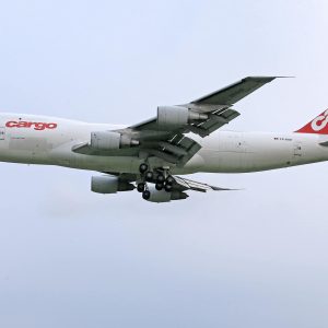 White cargo airplane flying against clear blue sky
