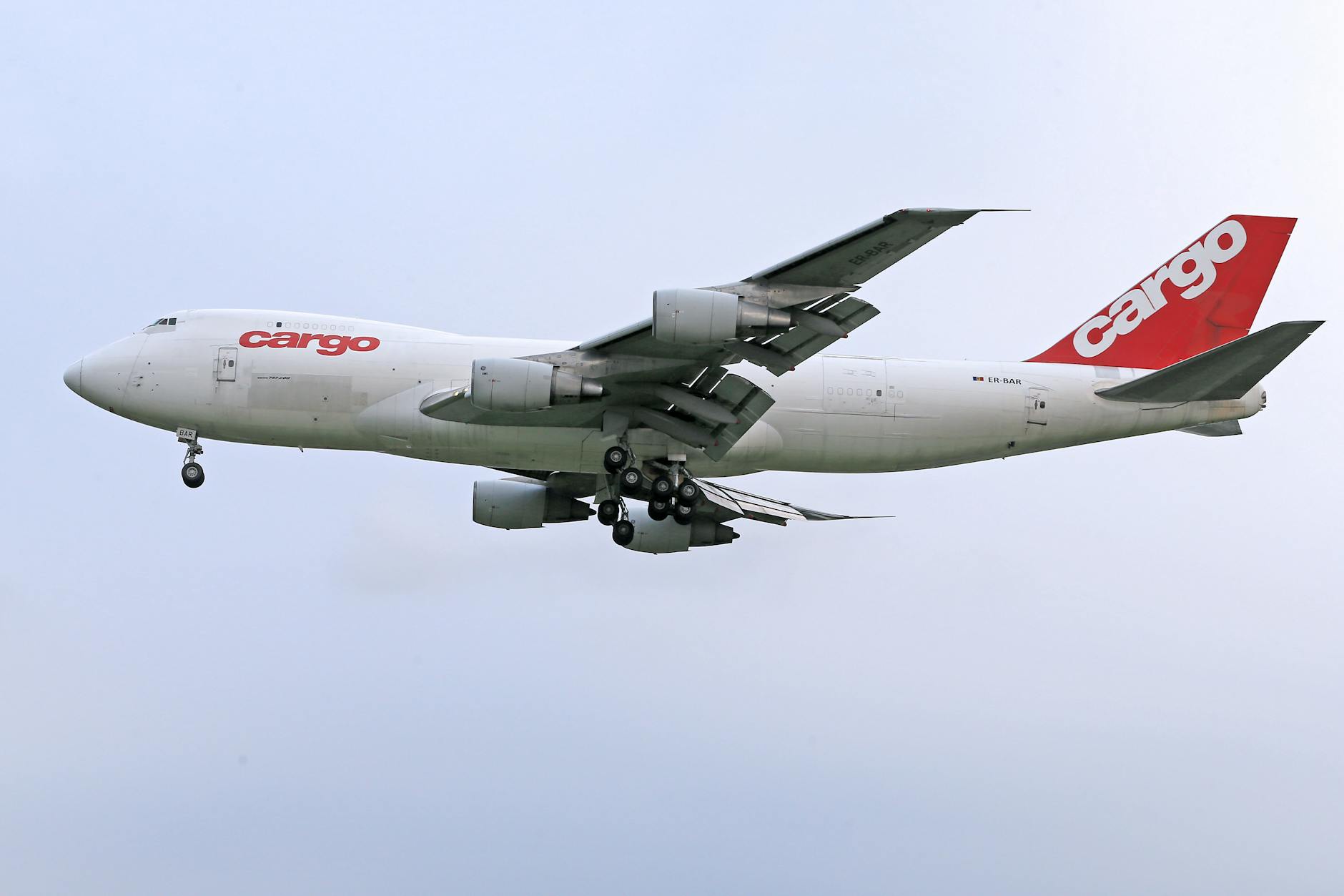 White cargo airplane flying against clear blue sky