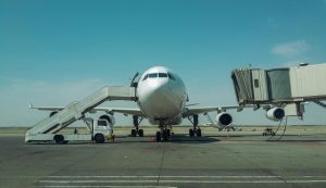 Large passenger plane stationed at airport with boarding stairs