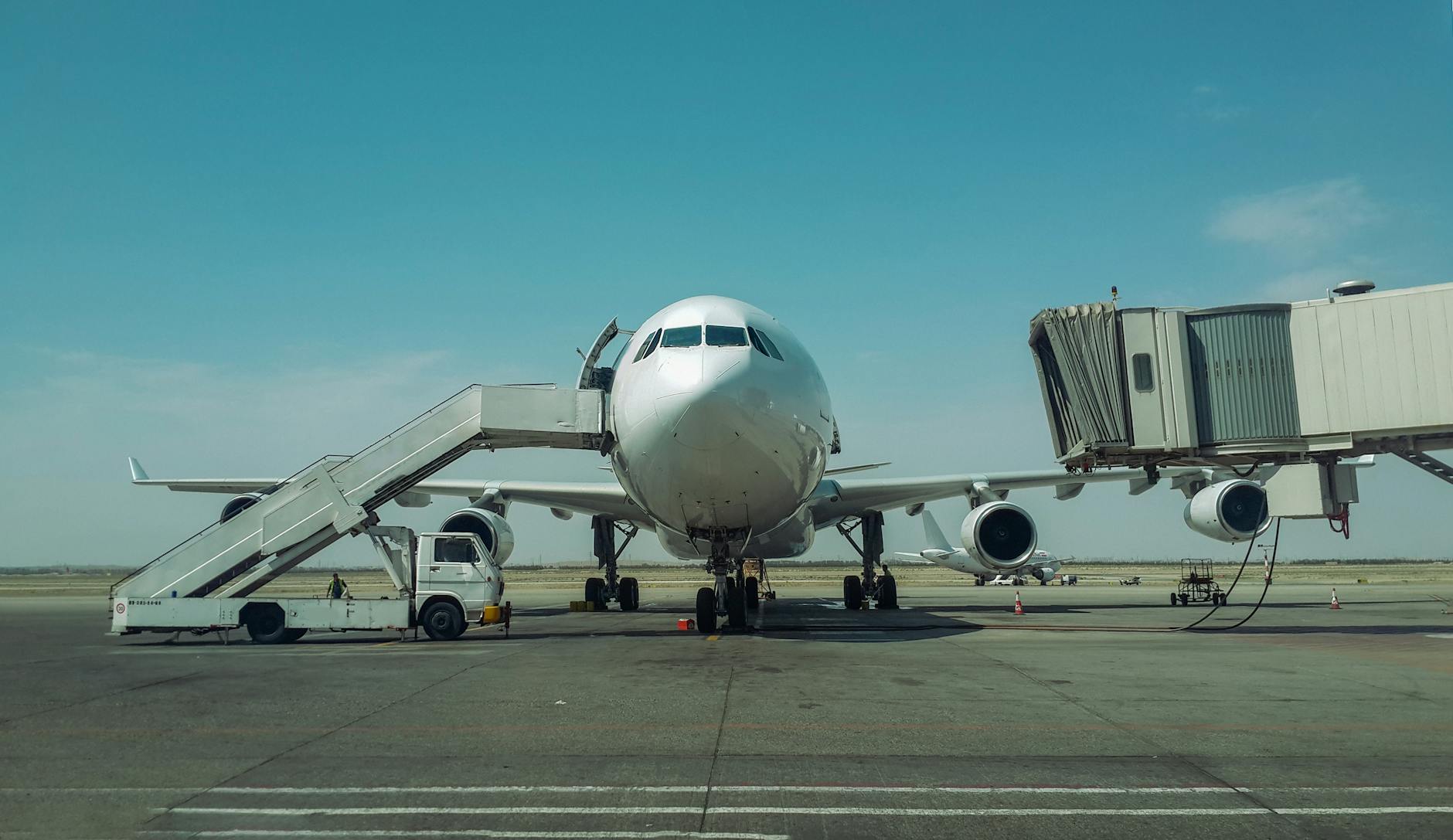 Large passenger plane stationed at airport with boarding stairs