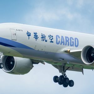 Large cargo airplane approaching landing under clear sky — global air cargo capacity 2026