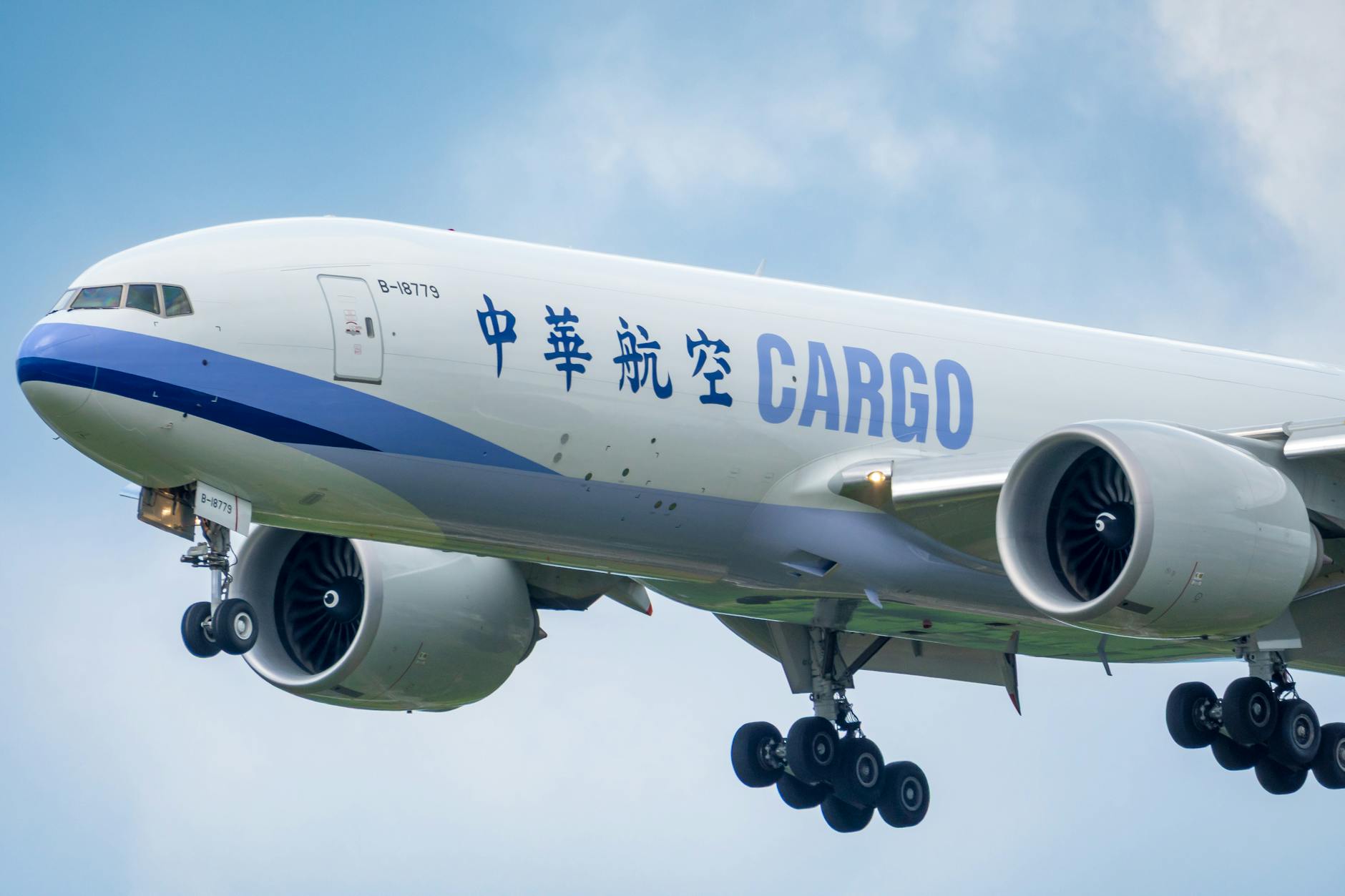 Large cargo airplane approaching landing under clear sky — global air cargo capacity 2026