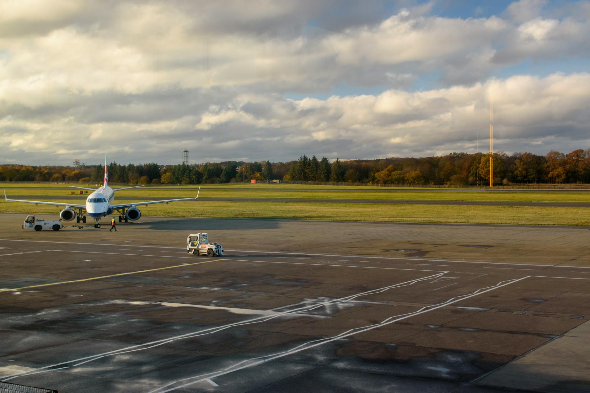 Commercial airplane stationed on tarmac under bright sky