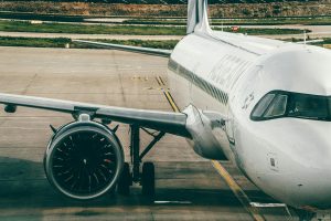 Airplane parked on airport tarmac showing engine and fuselage
