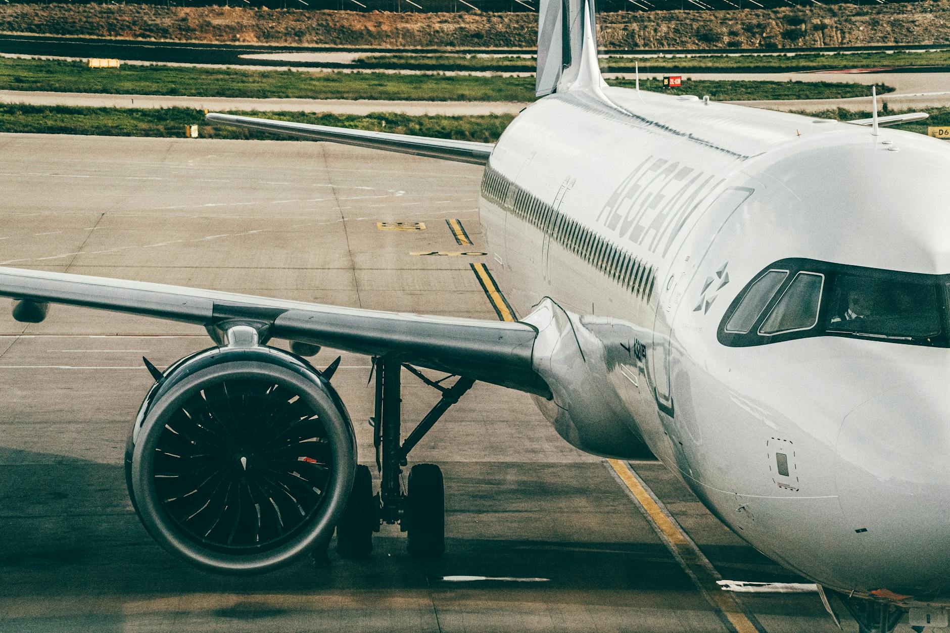 Airplane parked on airport tarmac showing engine and fuselage