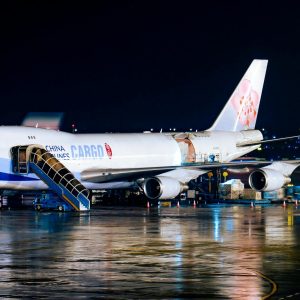Cargo airplane being loaded at night at airport with visible operations