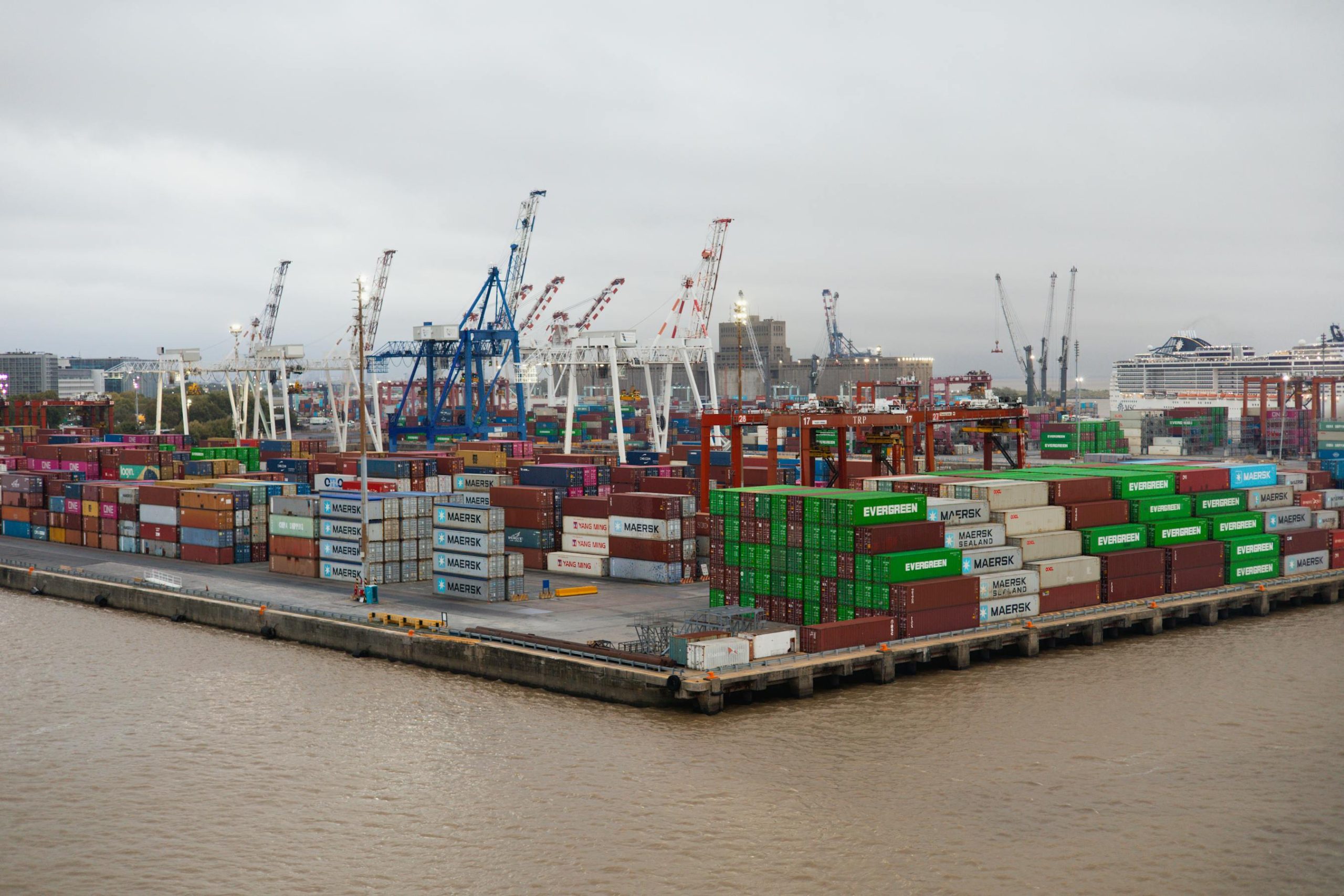 Bustling shipping port with stacked cargo containers and cranes, global logistics and freight